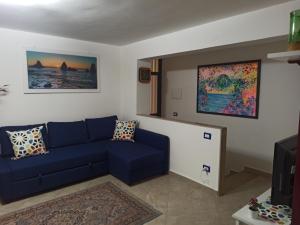 ein Wohnzimmer mit einem blauen Sofa und einem TV in der Unterkunft Il paradiso nascosto in Catania