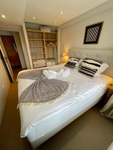 1 dormitorio con 1 cama grande con sábanas y almohadas blancas en Verbier Apt 2 rooms (3 guests), en Verbier