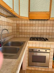 a kitchen with a sink and a stove at La Casa di Ivan in Marsala +11 photos