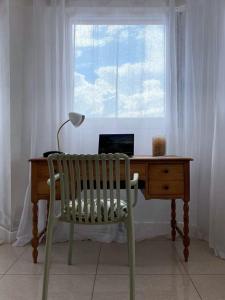 a desk with a chair and a lamp and a window at Appartement de charme Chez Soa in Antananarivo
