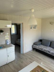ein Wohnzimmer mit einem Sofa und einer Küche in der Unterkunft Domki Milka in Ustka