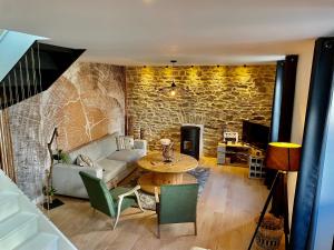 uma sala de estar com uma mesa e uma parede de pedra em Bella Vita Maison de charme au design soigné em Lorient