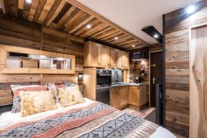 孔布盧的住宿－Le GoOfy, Centre, Navettes pistes ski Combloux，一间卧室设有一张大床和木墙