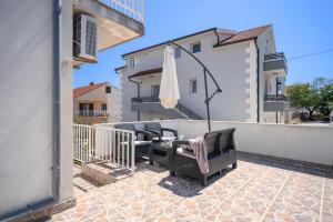 a patio with two chairs and an umbrella on a balcony at Apartments Bodlović in Hvar