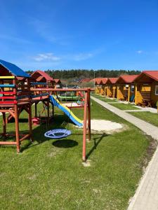 einen Park mit Spielplatz mit Rutsche in der Unterkunft Domki Milka in Ustka