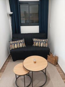 een woonkamer met een zwarte bank en een tafel bij Chambre studio aménagé in Cers