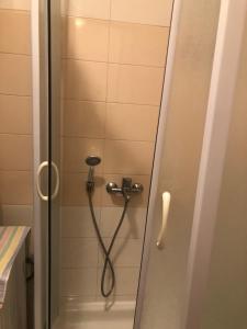 a shower with a hose in a bathroom at Apartman Tanjuška in Podgorica