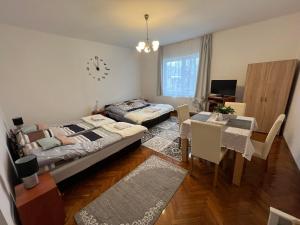 um quarto com 2 camas, uma mesa e um relógio em Komáromi Vendégház Erdőhorváti em Erdőhorváti