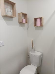 un bagno con servizi igienici e 2 scatole appese al muro di Chambre studio aménagé a Cers