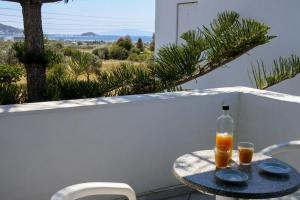 a table with two glasses of orange juice on a balcony at HOTEL KAPARI in Agia Anna Naxos