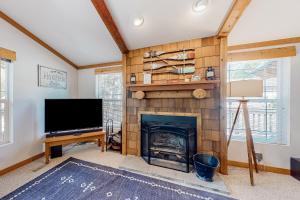 a living room with a fireplace and a flat screen tv at Riverfront Retreat in Sunriver