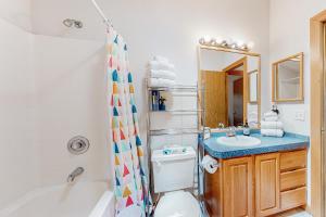 a bathroom with a tub and a toilet and a sink at Riverfront Retreat in Sunriver +27 photos