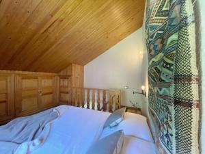 Schlafzimmer mit einem Bett mit Holzdecke in der Unterkunft Dúplex abuhardillado con vistas y parking in Vielha e Mijaran