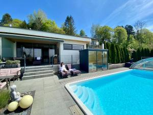 a woman sitting in a chair next to a swimming pool at Mostviertel Lodge in Ardagger Markt