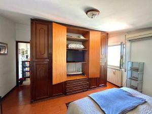 a bedroom with a bed and a large wooden cabinet at Casa40 Attico con terrazza in Rome