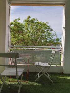 a table and a chair on a balcony with a table and a window at LE LAVARIN Balcon et Parking privé WIFI in Avignon