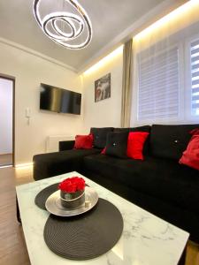 a living room with a black couch and a table at Apartament z jacuzzi in Kraków