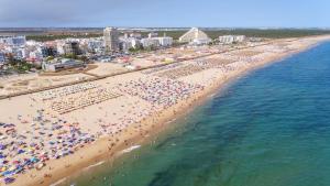 una vista aérea de una playa llena de gente en Sea Lovers - Sea front - studio apartment, en Monte Gordo