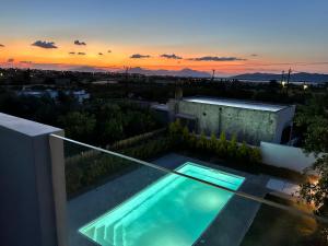 a swimming pool on the roof of a house with a sunset at Casa di Somnia Luxury Suites and Villas in Marmari