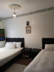 - une chambre avec 2 lits et un lustre dans l'établissement 105 Kasbah de Boujloud Fes Morocco., à Fès