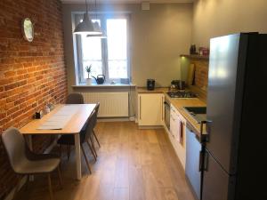 a kitchen with a table and a brick wall at Apartament BROWARNY in Ostrów Wielkopolski