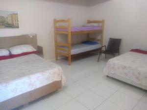 a bedroom with two beds and a bunk bed at Pousada Rota do Parque in Penha