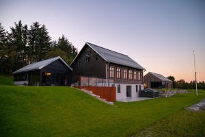 ein großes Haus auf einem Grashügel in der Unterkunft Godo Lodge in Godøy