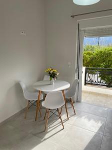 Biały stół i krzesła z wazonem kwiatów na nim w obiekcie Yannis Apartments w miejscowości Amoudara