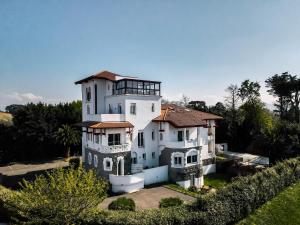 a large white house sitting on top of a yard at Résidence Château d'Acotz - Appartements avec piscine à 300m des Plages & Océan in Saint-Jean-de-Luz