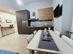 kuchnia z drewnianym stołem i białymi krzesłami w obiekcie La Little Prince A casa come in una favola w Turynie +13 zdjęć