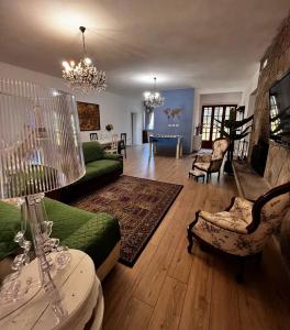 a living room with a green couch and a living room with a fireplace at Agriturismo Villa Paradiso - appartamenti con piscina in Fauglia
