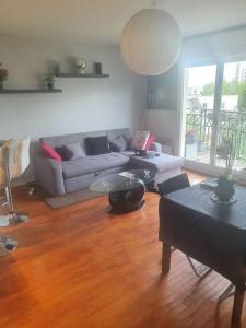 sala de estar con sofá y suelo de madera en superbe appartement, en Châtillon