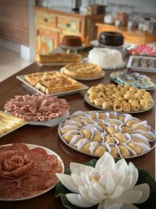 a table with many different types of food on plates at Pousada Mar à Vista in Ilha de Boipeba