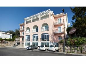 a pink building with cars parked in front of it at Hotel Britannia in Sorrento