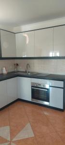 a kitchen with white cabinets and a stainless steel microwave at Apartments Donadic I, Caska in Novalja