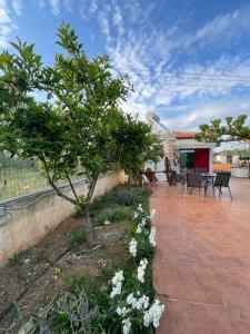 a garden with a tree and flowers on a patio at Country Lux Apartment near Airport in Markopoulo