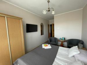 ヤストシェンビャ・グラにあるKojakのベッド1台と椅子2脚が備わるホテルルームです。