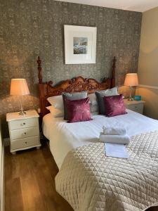 a bedroom with a large bed with purple pillows at Sycamore Lodge in Kilkee