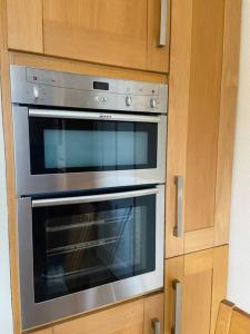 a stainless steel oven in a kitchen with wooden cabinets at Tullybrannigan Cottage Newcastle in Newcastle