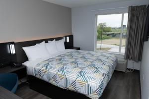 a bedroom with a bed and a large window at Motel 6 Fort Worth TX Lake Worth in Fort Worth