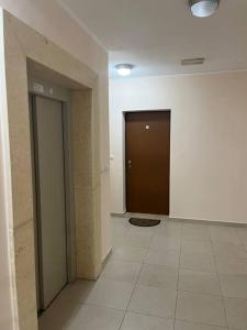 pasillo vacío con 2 puertas y suelo de baldosa en Lovely apartment with the parking place, en Podgorica