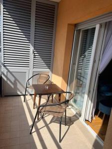 una mesa y sillas en el balcón de una casa en Lovely apartment with the parking place, en Podgorica