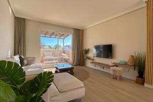 sala de estar con sofá y TV en Luxurious penthouse with 180m2 sunlit terrace, en Estepona