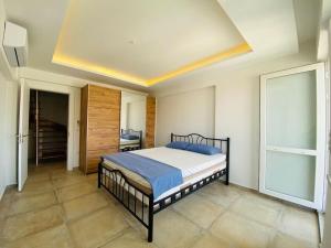 een slaapkamer met een bed in een kamer bij Full MANZARALı GENiŞ TeRaSLı HAVUZSUZ TATİL EVİ in Kuşadası