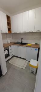 a kitchen with white cabinets and a sink at Apartman Jakša in Prijedor