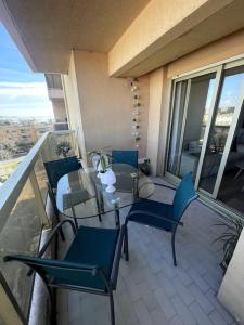 eine Terrasse mit einem Tisch und Stühlen auf dem Balkon in der Unterkunft Appartement cosy vue mer, 5min à pied de la plage, parking in Vallauris
