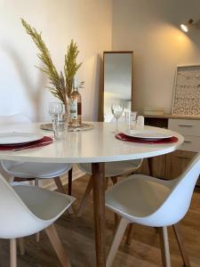 einen weißen Tisch mit 2 Stühlen und eine Flasche Wein in der Unterkunft Appartement cosy vue mer, 5min à pied de la plage, parking in Vallauris