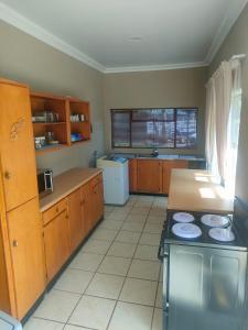 a kitchen with wooden cabinets and a stove in it at 19 Wawiel Guesthouse in Orkney
