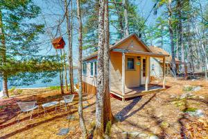 a tiny house in the woods with two chairs and a tree at Waterfront Serenity in Raymond