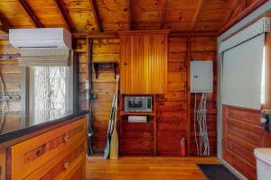 a room with a kitchen with wooden walls and wooden floors at Waterfront Serenity in Raymond